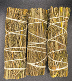 Three bundles of lavender sticks tied together on a dark background