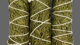 Bundles of cedar tied with white string on a white background