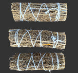 Three bundles of lavender tied with white string on a black background