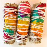 Three colorful smudge sticks with rainbow patterns on a light background