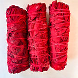 Three bundles of white sage dyed with dragons blood on a white background