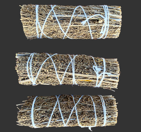 Three bundles of lavender tied with white string on a black background